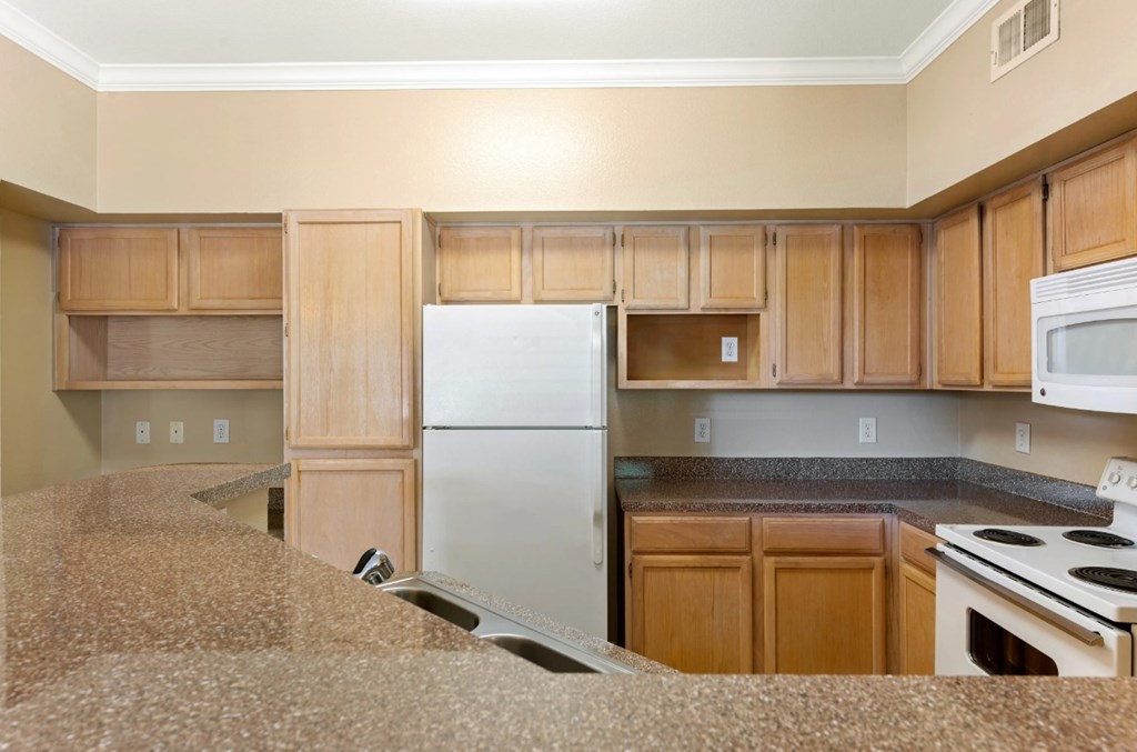 A kitchen with wooden cabinets and a white refrigerator.