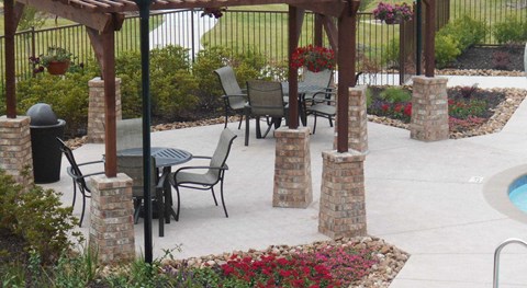 A patio with a table and chairs under a pergola.