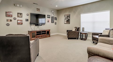 A living room with a television, a couch, and a chair.