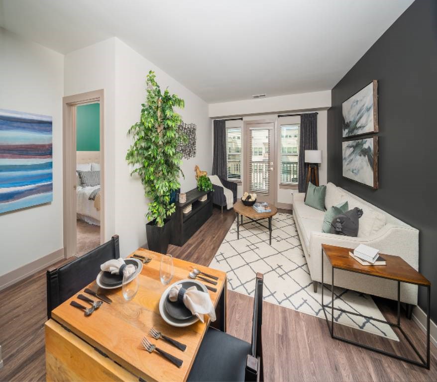 One Bedroom Apartments in Silver Spring, MD - Atelier Apartments - Living Room Featuring Dining Table With Chairs, Wood-Style Flooring, and Patio/Balcony Access