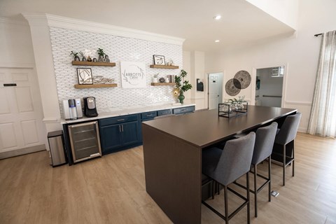 A kitchen with a long table and chairs.