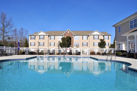A large building with a pool in front of it.