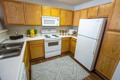 A kitchen with wooden cabinets and white appliances.