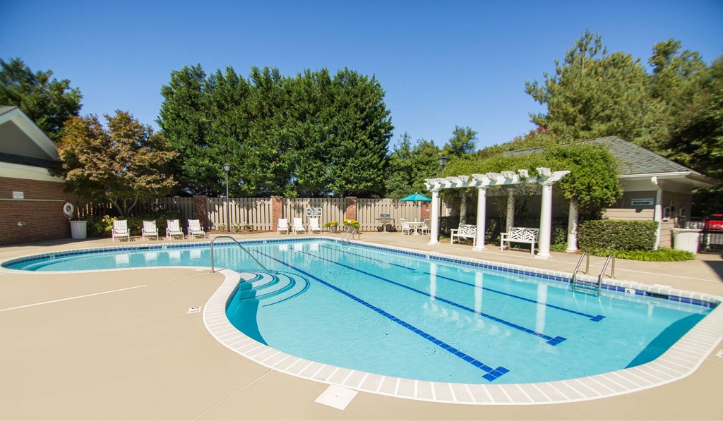 A large outdoor swimming pool with a pavilion in the background.