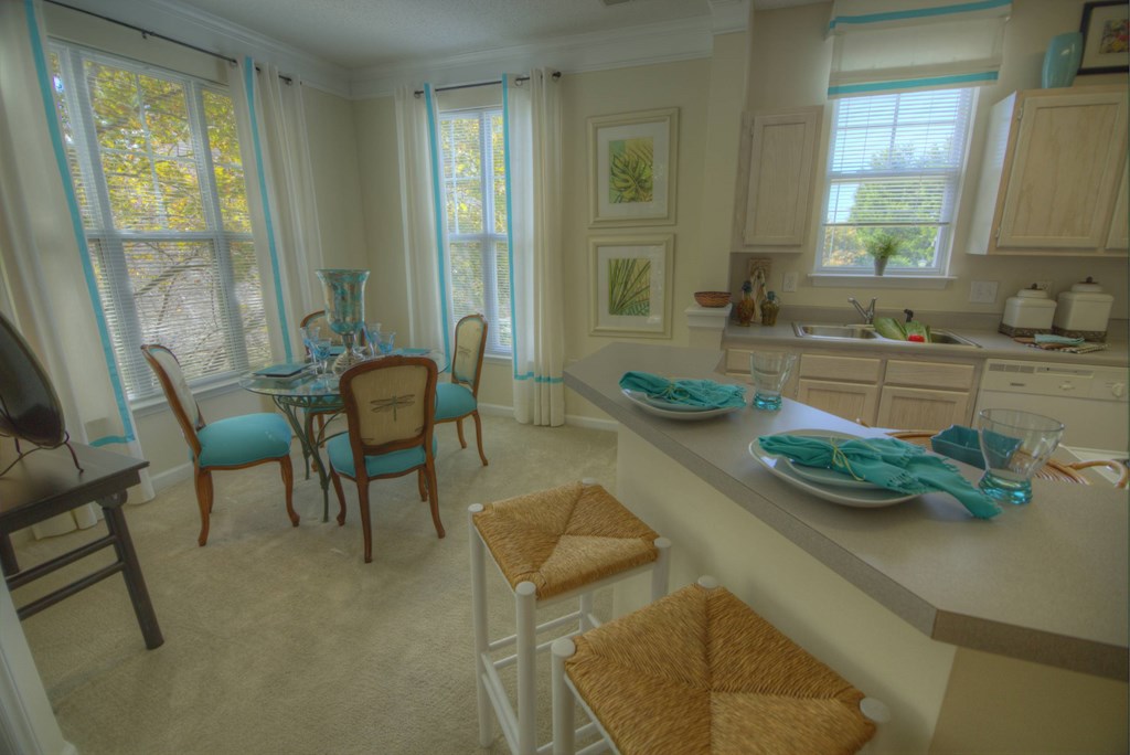 A kitchen with a table and chairs.
