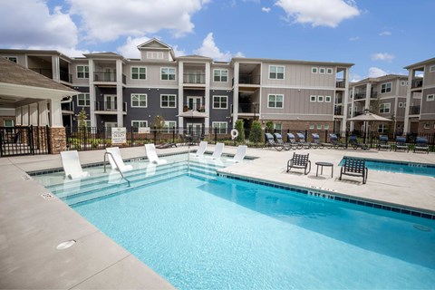 A swimming pool in front of apartment buildings.