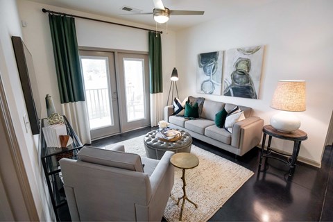 A living room with a grey couch, a coffee table, and a painting on the wall.