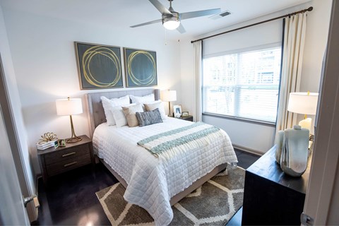 A bedroom with a bed, nightstands, and a ceiling fan.