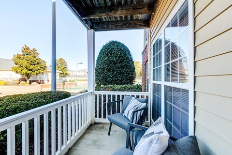 A small balcony with a bench and pillows.