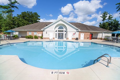 A swimming pool in front of a house with a sign that says 5 FT 15M.