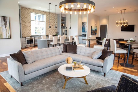 A modern living room with a grey sofa set and a chandelier.