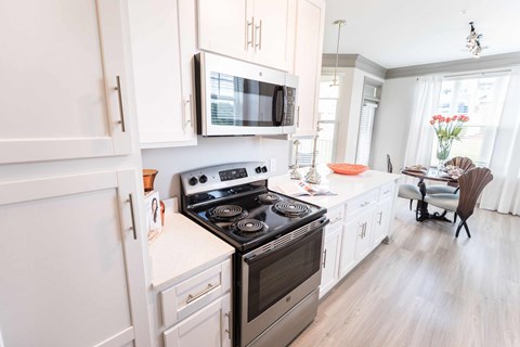 A modern kitchen with a stove top oven and microwave above it.