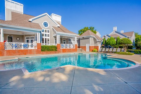 A house with a pool in front of it.