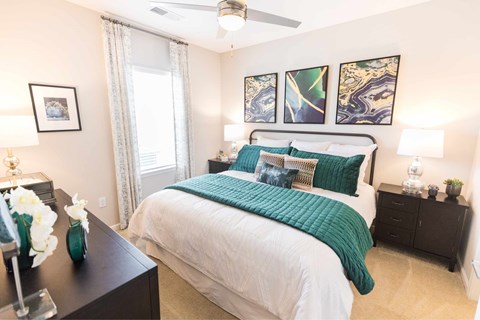 A bedroom with a large bed and a ceiling fan.