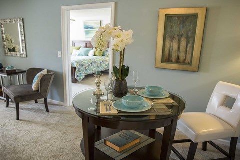 A dining room with a round table set for two.