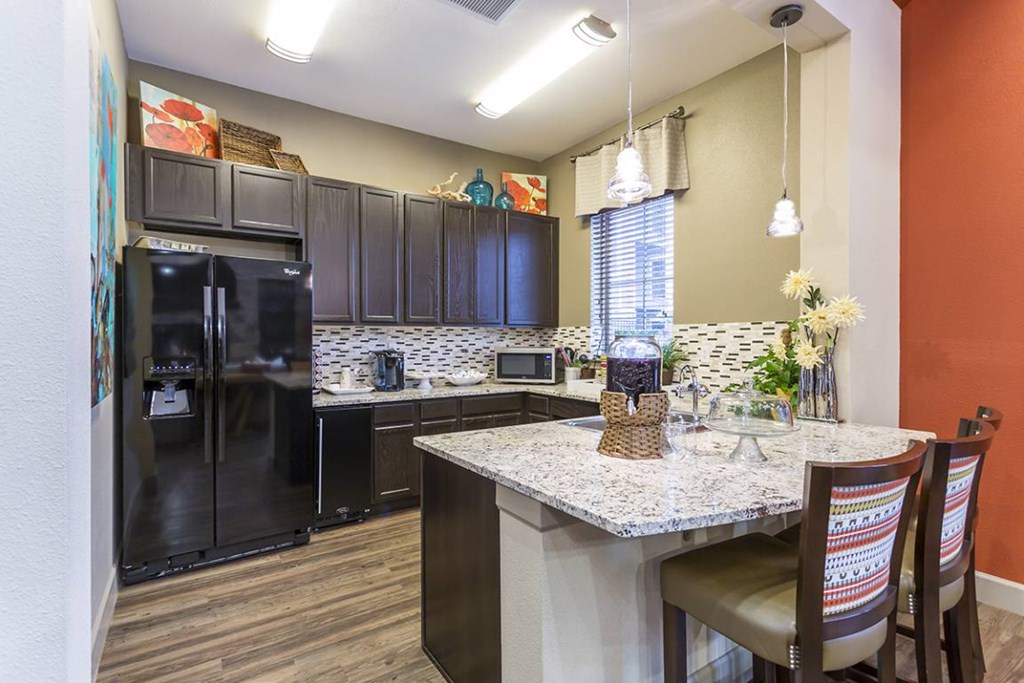 A kitchen with a black fridge and a white counter top.