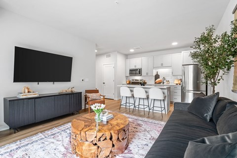 A modern living room with a grey couch and a wooden coffee table.