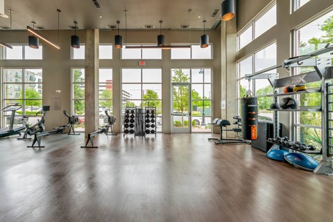 A gym with a variety of equipment including treadmills, weights, and exercise machines.