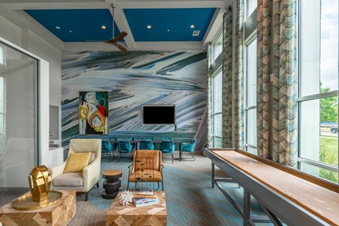 A living room with a blue ceiling and a large painting on the wall.