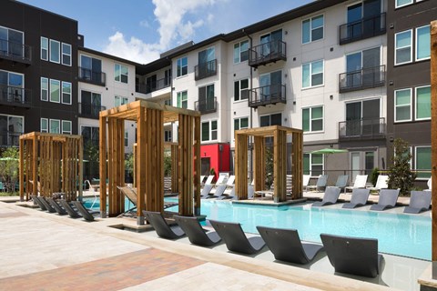 A pool area with chairs and a wooden structure.