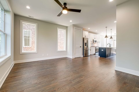 A spacious room with a ceiling fan and wooden flooring.