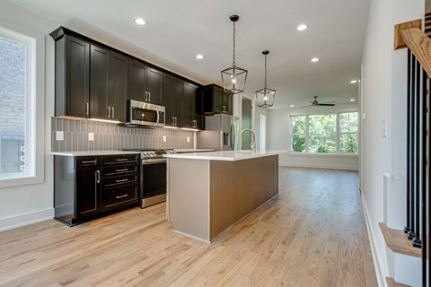 A kitchen with black cabinets and a wooden island.