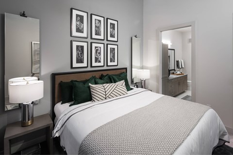 A bedroom with a large bed and a mirror on the wall.