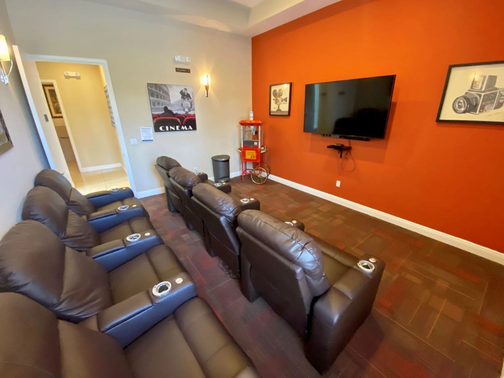 A row of brown leather reclining seats in a room.