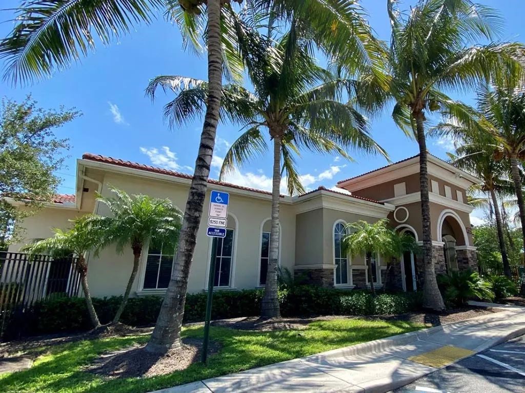 A building with a blue sign on a pole in front of it.