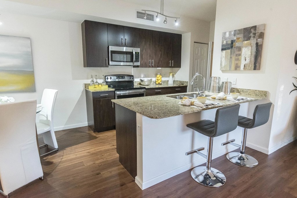 A kitchen with a bar stool and a counter.