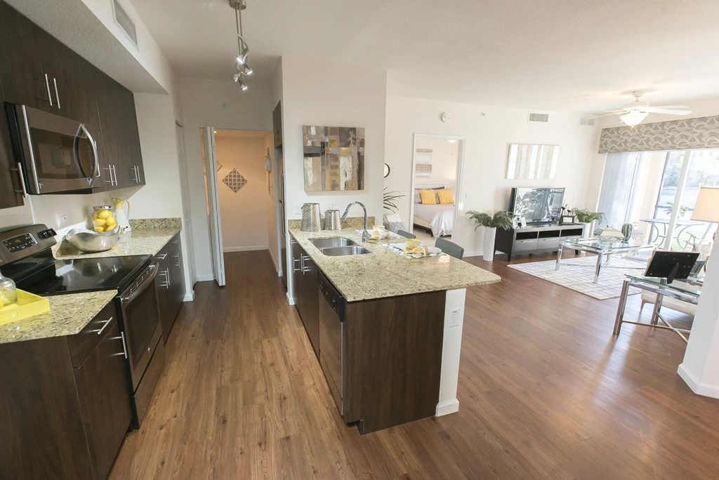 A kitchen with dark wood cabinets and granite countertops.