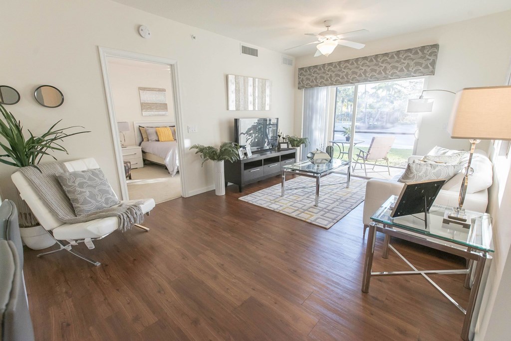 A living room with a white chair and a glass table.