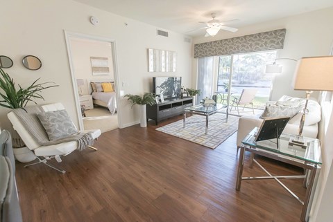 A living room with a white chair and a glass coffee table.
