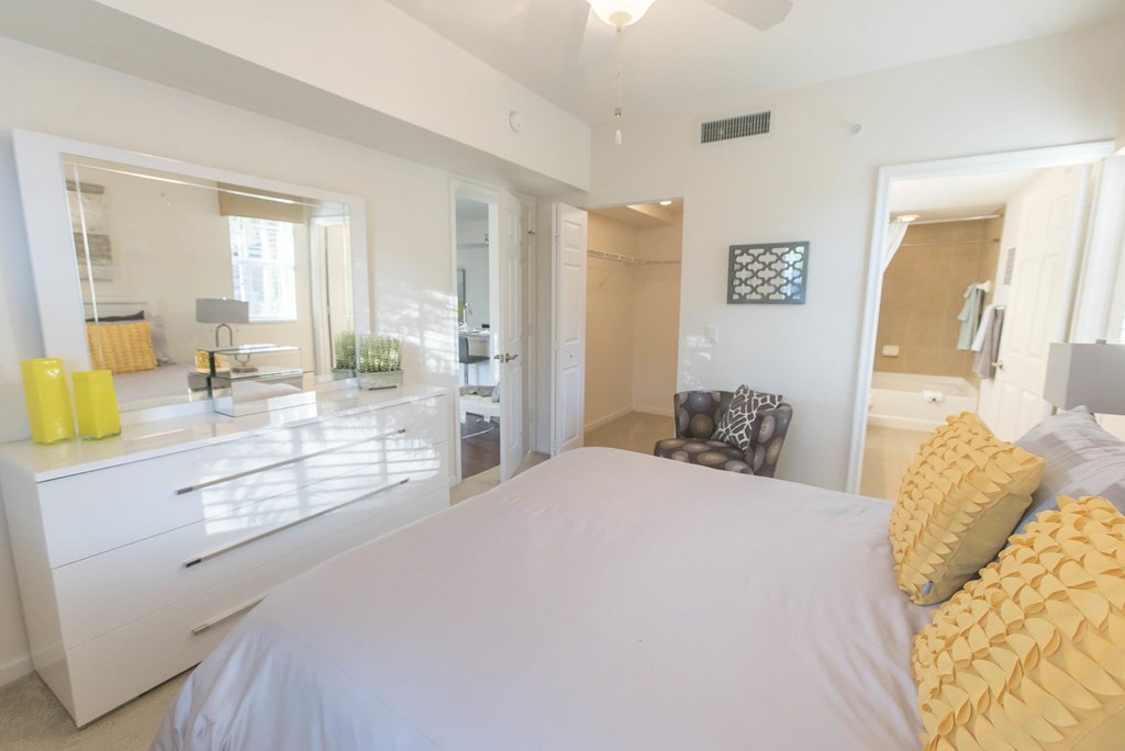 A bedroom with a large bed and a chair.