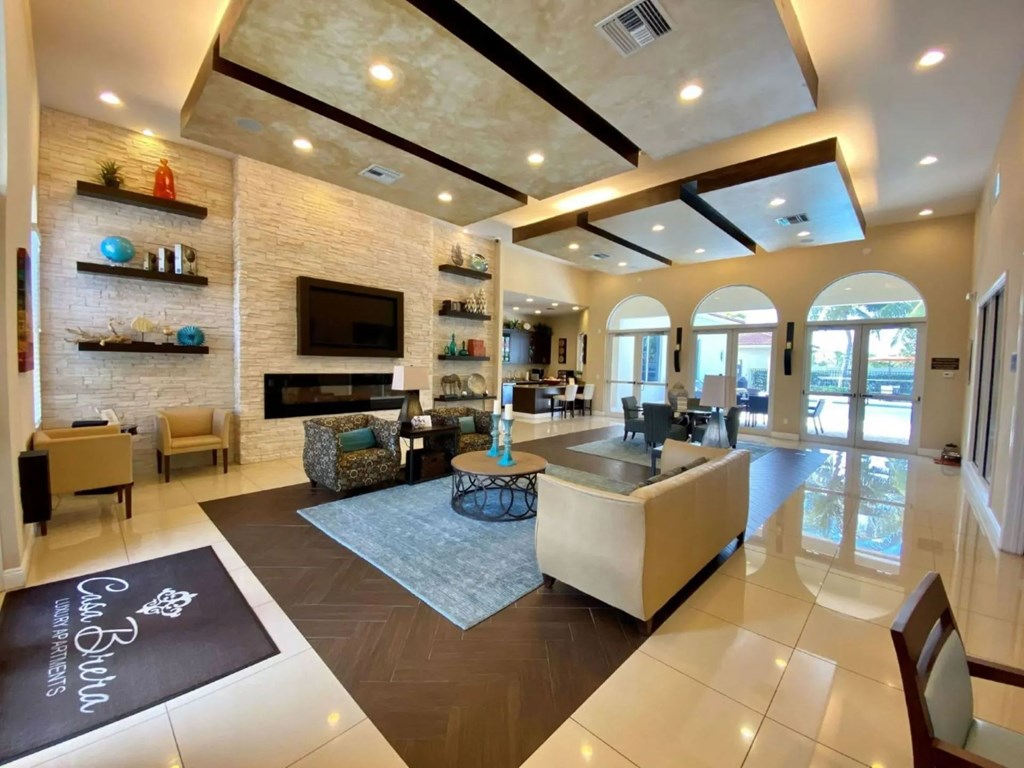 A spacious living room with a fireplace and a large rug on the floor.