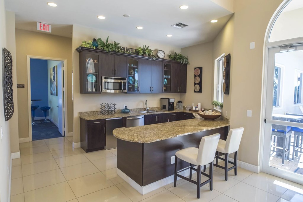 A kitchen with a granite counter top and a bar stool.