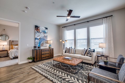 A living room with a large painting on the wall and a wooden floor.