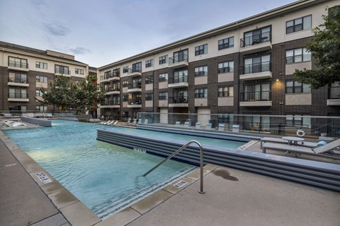 A swimming pool in front of apartment buildings.