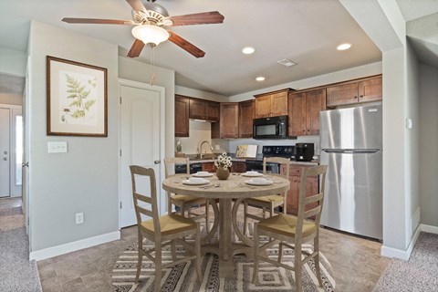 A kitchen with a table and chairs in the middle of the room.