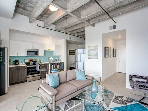 A modern living room with a glass coffee table and a couch.