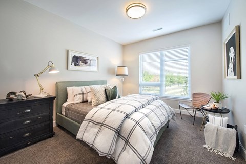 Luxury Apartments in Berkley Riverfront, MO, with In-Unit Washer and Dryer - Union Berkley - Living Room with Wood-Style Flooring, Area Rug, Sofa, Wooden Chest Coffee Table, Armchair, and Floor Lamp.