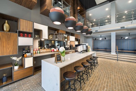 A modern kitchen with a white counter and bar stools.