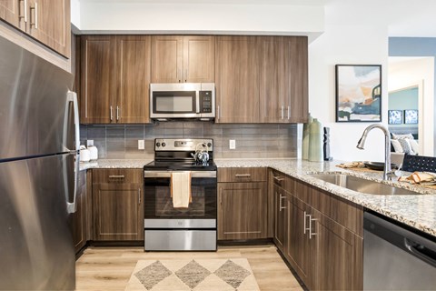 A modern kitchen with wooden cabinets and stainless steel appliances.