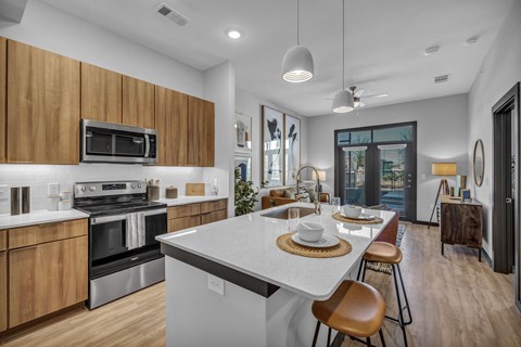 A modern kitchen with wooden cabinets and a white island.