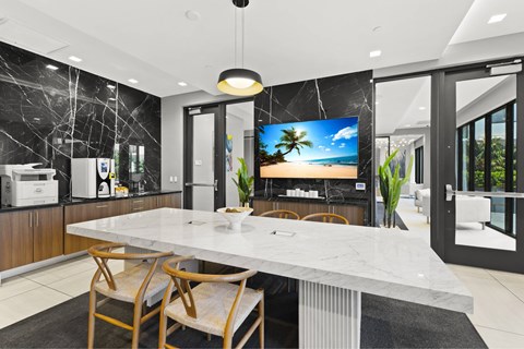 A modern kitchen with a marble table and chairs.