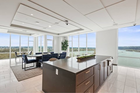 A modern kitchen with a large island and a dining table with chairs.