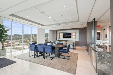 A conference room with a long table and chairs, a television, and a view of the city.