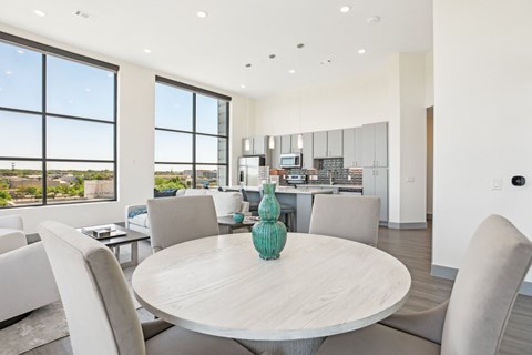 A modern dining room with a large table and chairs.