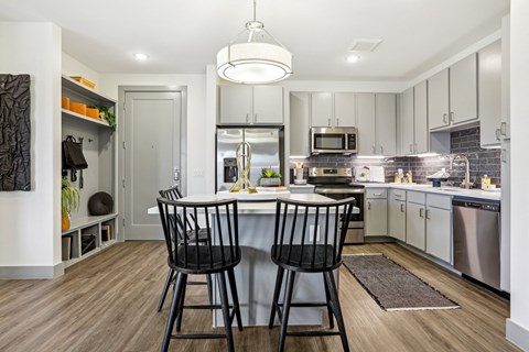 A modern kitchen with a dining table and chairs.