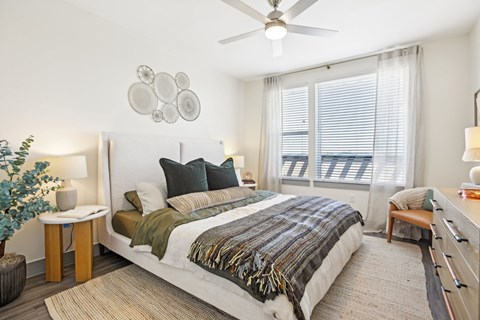 A bedroom with a large bed and a ceiling fan.